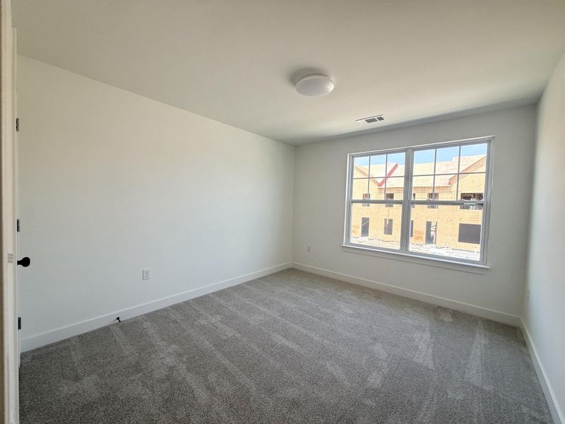 Spare room featuring carpet floors and baseboards