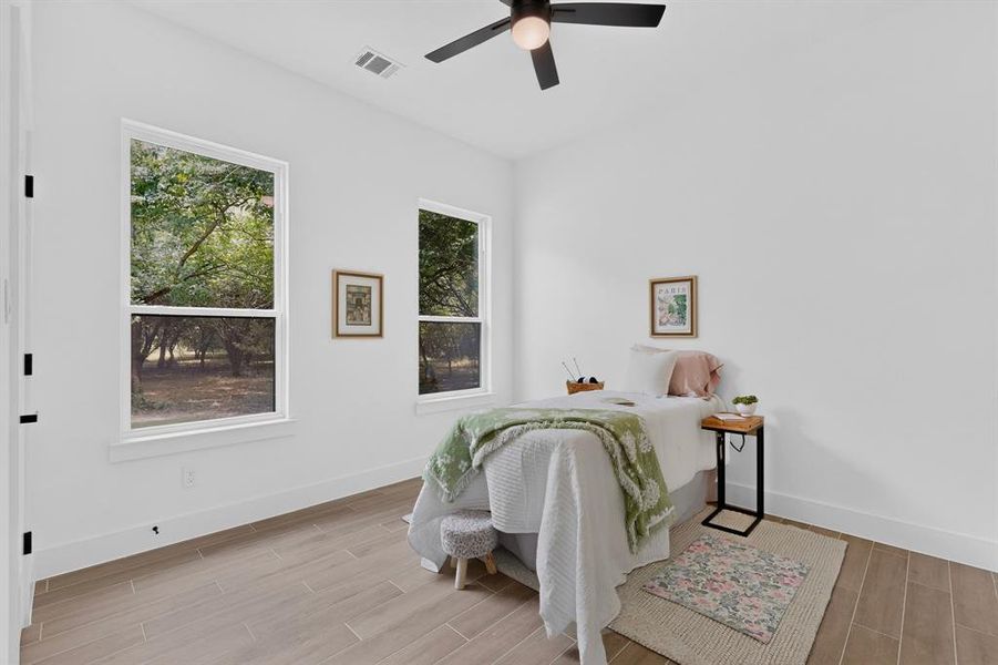 Bright interior room featuring wood-finish flooring, white walls, and a ceiling fan