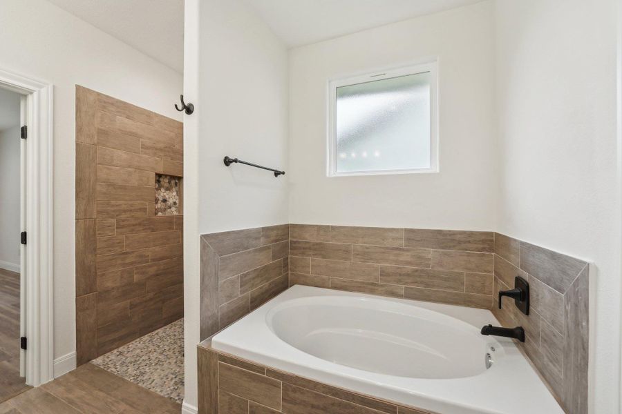 Bathroom featuring a bath, wood plant Tile floors, and a tile shower Bathroom featuring a bath, wood plant Tile floors, and a tile shower