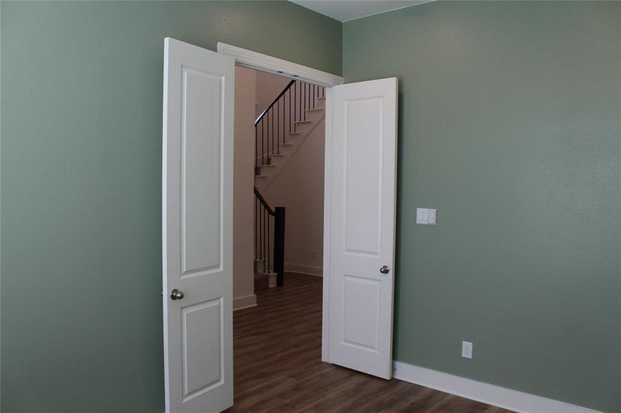 Spare room with dark wood finished floors and stairs