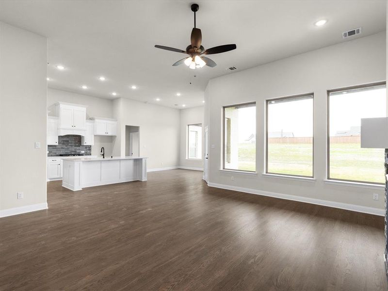 Unfurnished living room featuring dark wood-style floors, recessed lighting, and ceiling fan
