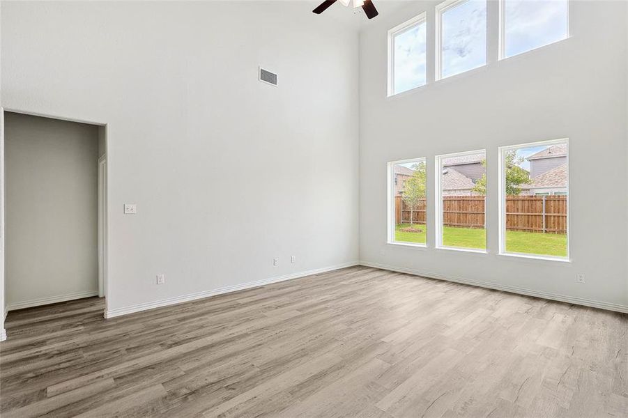 Unfurnished room featuring ceiling fan, a healthy amount of sunlight, and light hardwood / wood-style flooring