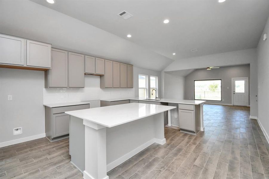 The open concept seamlessly connects this culinary haven to the expansive family room, creating the perfect hub for gatherings. Sample photo of completed home. As-built color and selections may vary.