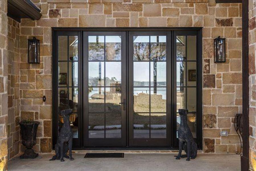 Entrance to property with a water view and french doors