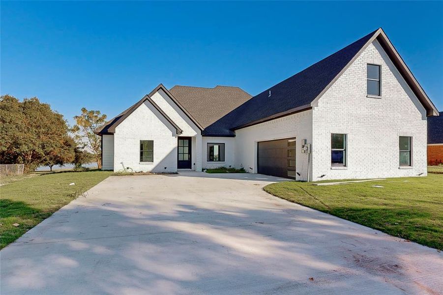 Modern inspired farmhouse featuring a garage and a front yard