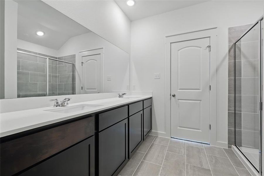 Bathroom featuring double vanity, a stall shower, and recessed lighting