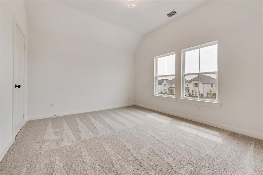Additional living space featuring light colored carpet and lofted ceiling Additional living space featuring light colored carpet and lofted ceiling