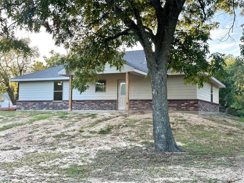 View of front of property featuring brick siding and a shingled roof