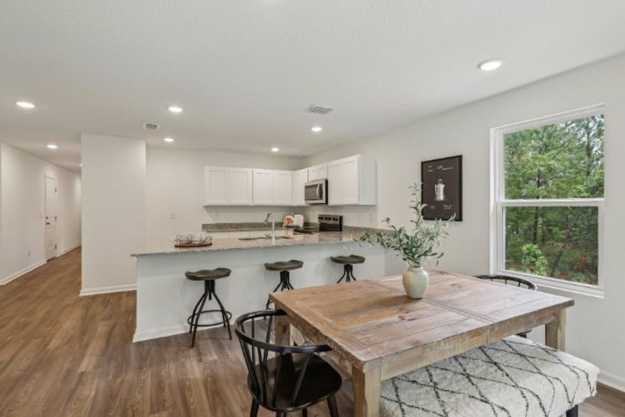 A kitchen with a table and chairs.