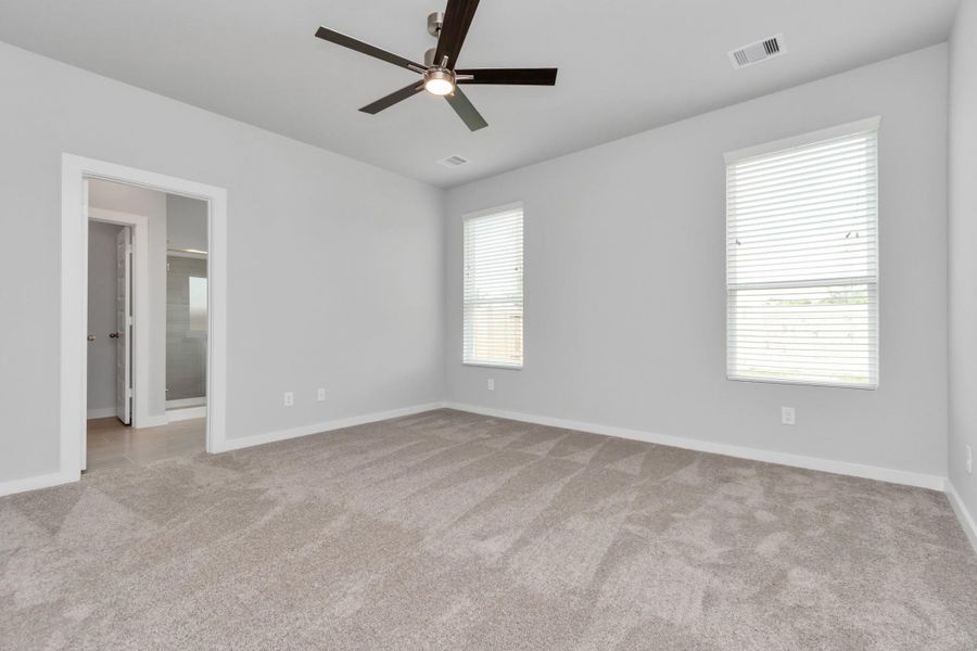 Recharge in the opulent primary suite after a demanding day! Luxuriate in the plush carpeting, soothing paint palette, elevated ceilings, and expansive windows equipped with privacy blinds. Sample photo of completed home with similar floor plan. Actual colors and selections may vary.