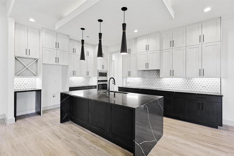 Kitchen with dark cabinetry, a spacious island, wood tiled floors, white cabinets, and recessed lighting Kitchen with dark cabinetry, a spacious island, wood tiled floors, white cabinets, and recessed lighting