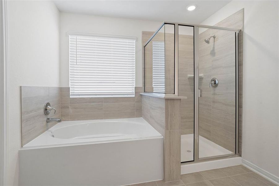 Additional view of the primary bathroom displaying the dark framed walk-in shower and large garden tub with tile surround, custom paint, sleek and dark modern finishes!