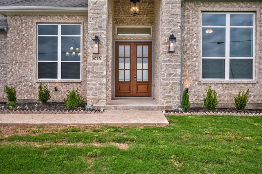 Entrance to property with a lawn and brick siding Entrance to property with a lawn and brick siding