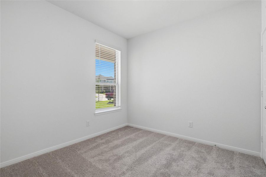 Nestled in the front of this home, the secondary bedroom offers comfort and style with plush carpeting, neutral paint tones, recessed lighting, a large window with blinds, and a generously sized closet. Nestled in the front of this home, the secondary bedroom offers comfort and style with plush carpeting, neutral paint tones, recessed lighting, a large window with blinds, and a generously sized closet.