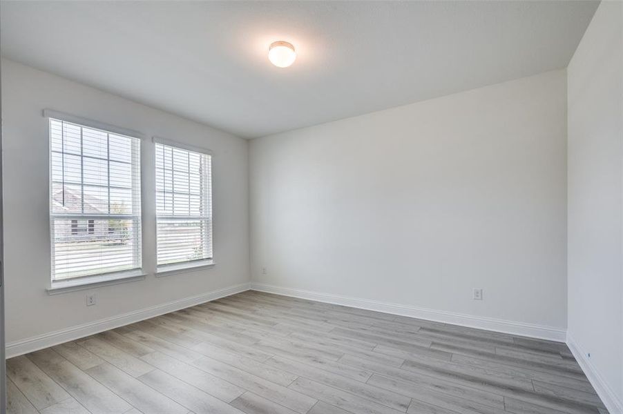 Empty room with baseboards and light wood-style floors Empty room with baseboards and light wood-style floors