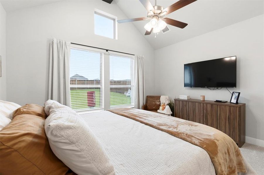 Primary bedroom with ceiling fan and a transom window for natural light Primary bedroom with ceiling fan and a transom window for natural light