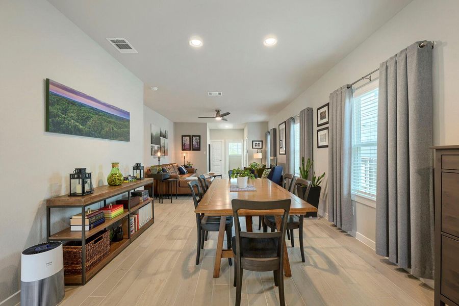 An open concept living and dining area boasts elegant wood flooring and abundant natural light. An open concept living and dining area boasts elegant wood flooring and abundant natural light.