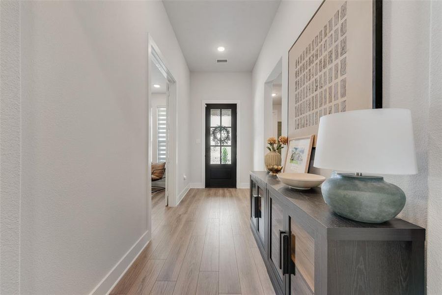 Entry hall featuring wood-finish flooring, recessed lighting, and white baseboards