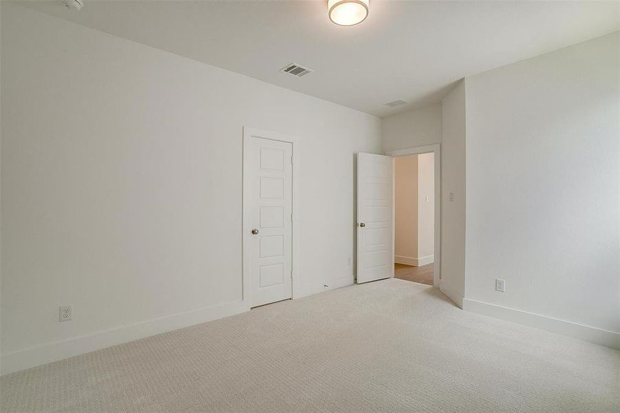 Unfurnished bedroom with light colored carpet and a closet