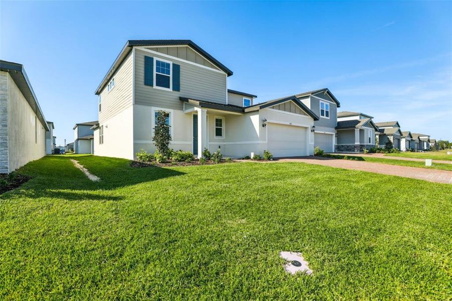 Front exterior of a new home in The Meadow at Crossprairie, St. Cloud, FL, highlighting curb appeal (Image 26).