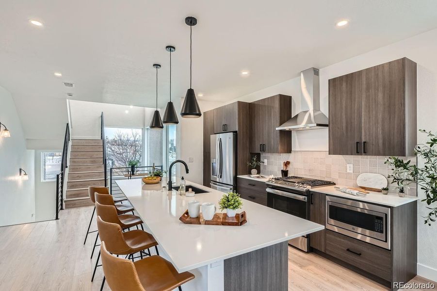 Second level is brightened by natural light from large windows. Kitchen includes all appliances and island seating.