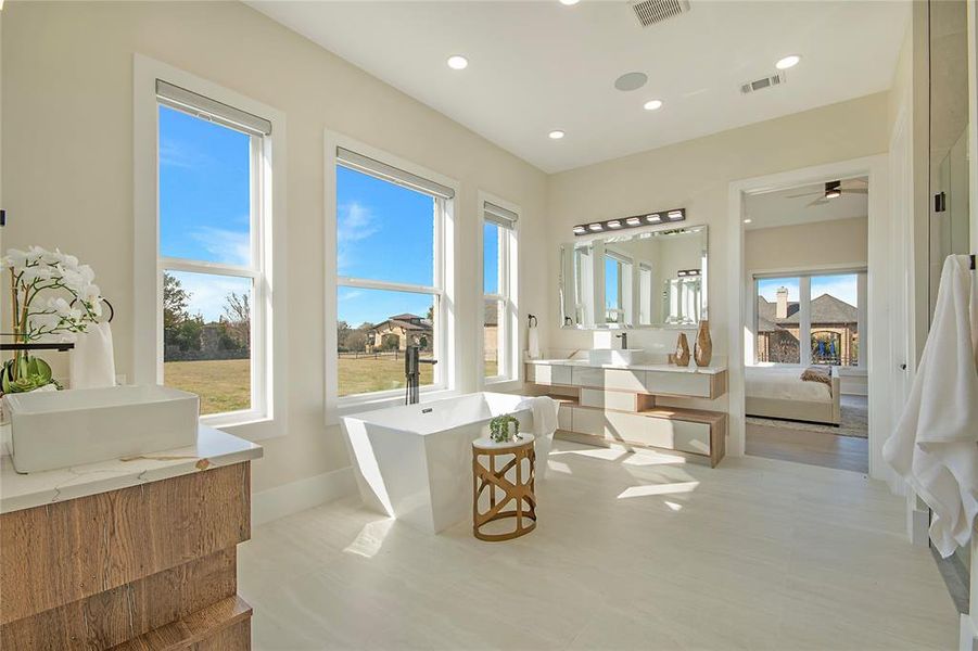 Ensuite bathroom with a freestanding bath, vanity, recessed lighting, and ceiling fan Ensuite bathroom with a freestanding bath, vanity, recessed lighting, and ceiling fan