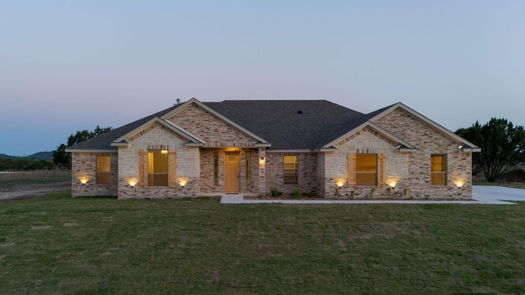 View of front of property featuring brick siding, a front yard, and roof with shingles View of front of property featuring brick siding, a front yard, and roof with shingles