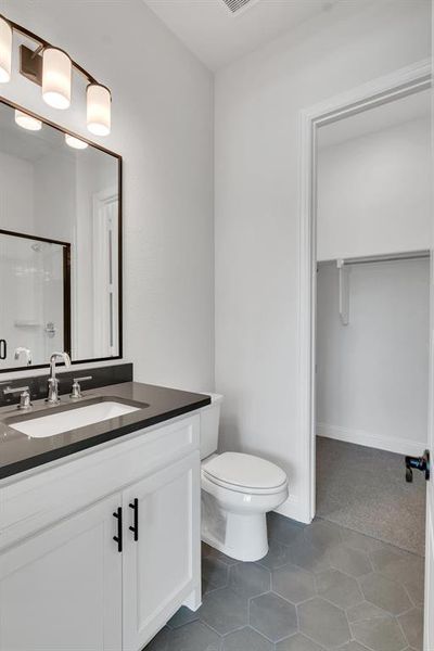 Bathroom featuring vanity, toilet, and tile patterned floors