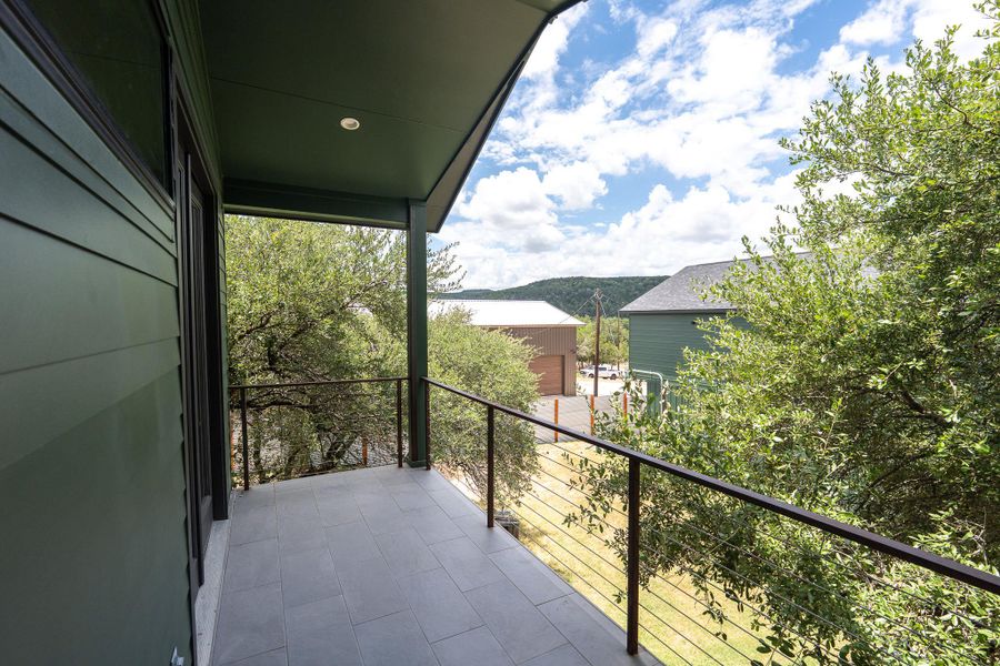 Primary Room Balcony: A tiled balcony extends from the home, offering an elevated perspective of the surrounding natural landscape and distant hills. Primary Room Balcony: A tiled balcony extends from the home, offering an elevated perspective of the surrounding natural landscape and distant hills.