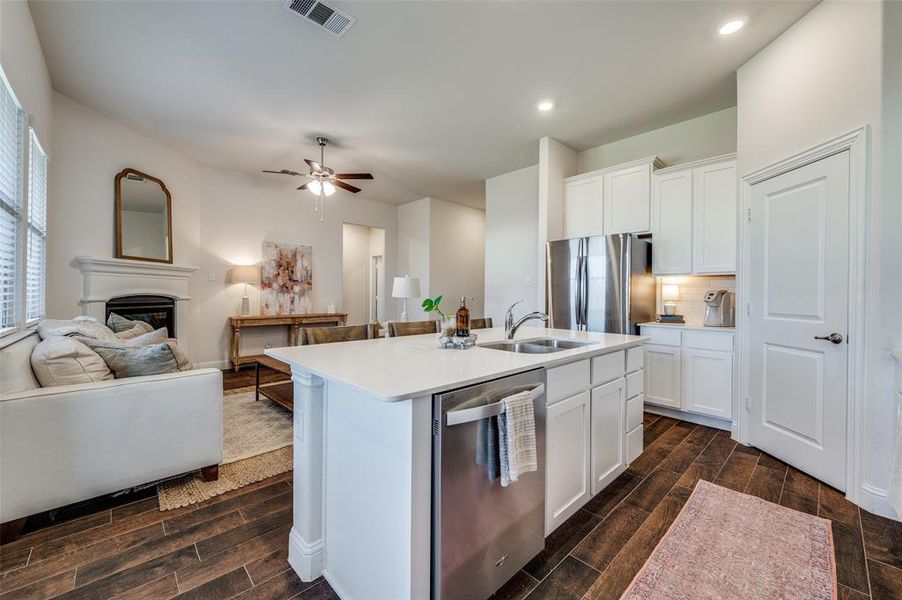 Kitchen with sink, stainless steel appliances, a center island with sink, and white cabinets