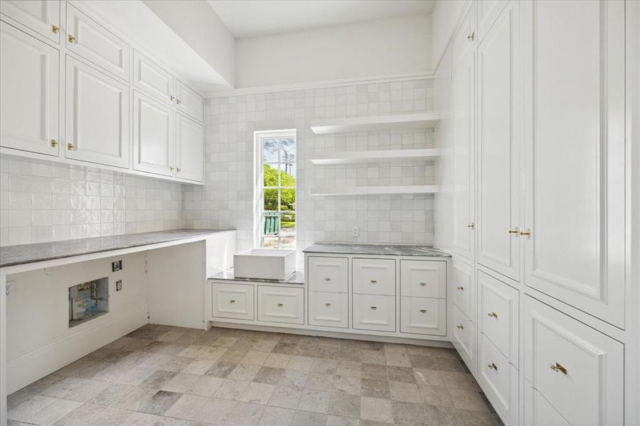 The utility room features a spacious layout with several built-in cabinets, drawers, and plenty of counter space.