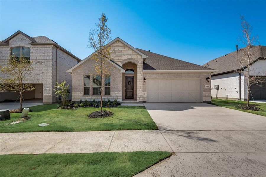 Traditional home with a 2 car garage and a front yard