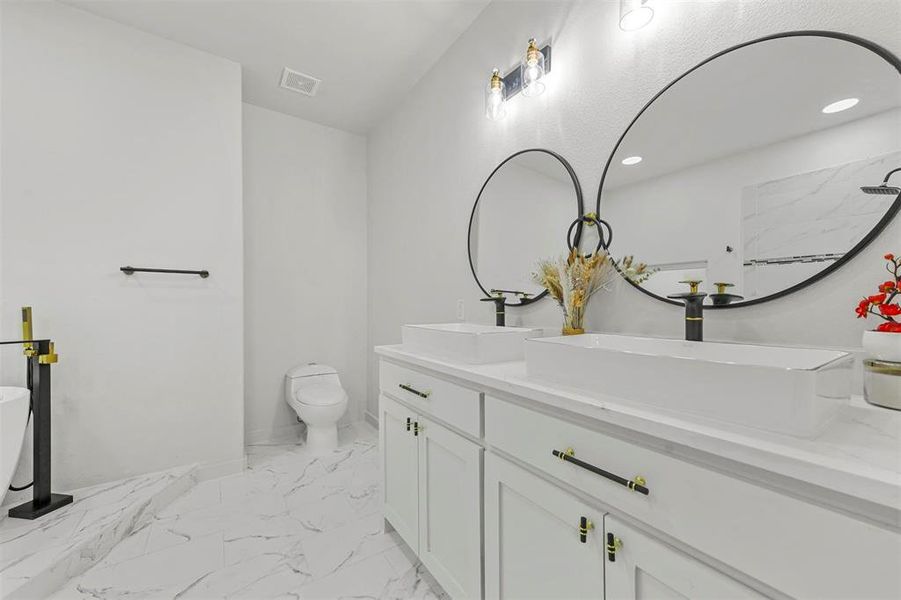 Full bathroom with tiled shower / bath, vanity, and toilet