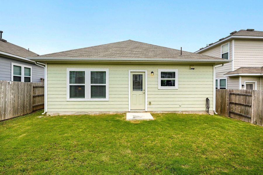 A private, fenced backyard offers a verdant lawn and ample space for outdoor enjoyment. A private, fenced backyard offers a verdant lawn and ample space for outdoor enjoyment.