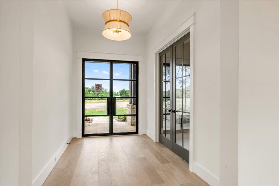 Doorway with wood finished floors and french doors