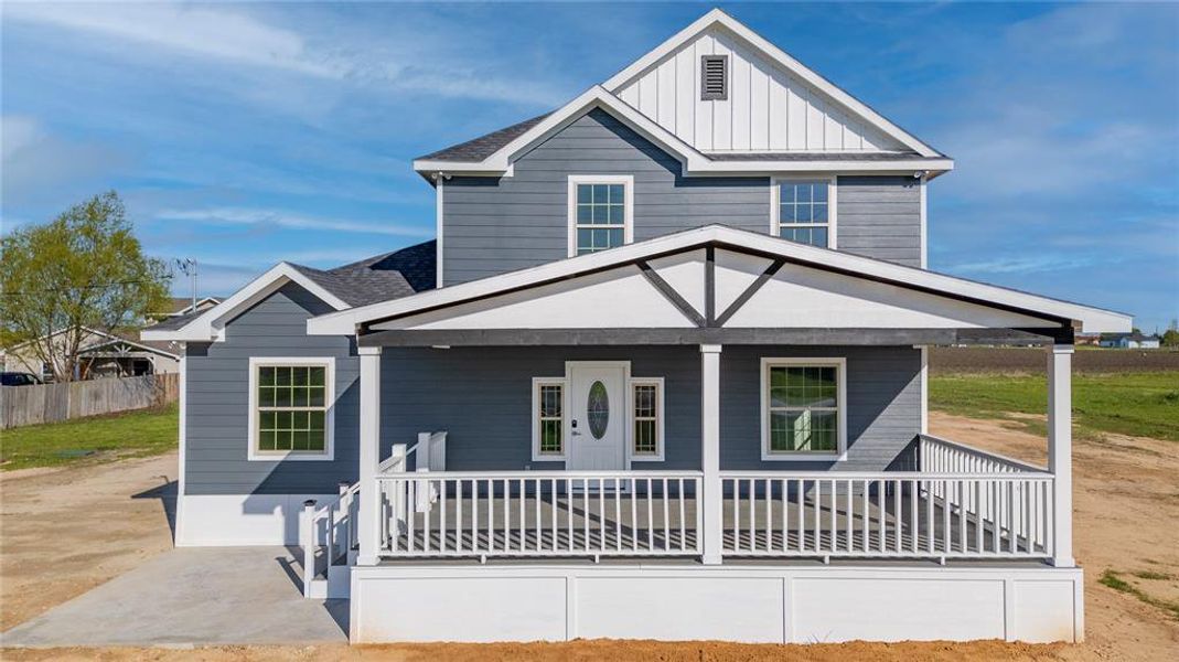 View of front of house with board and batten siding, a porch, a shingled roof, and fence