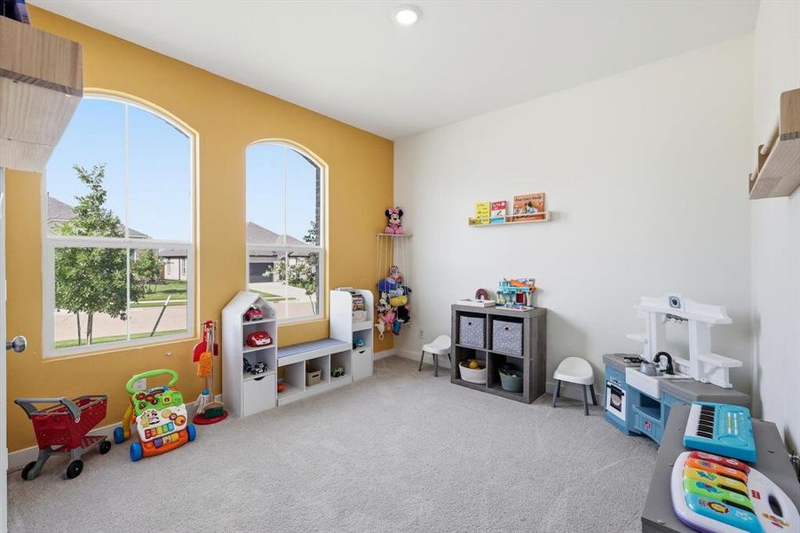 Spacious room featuring arched windows, soft carpeting, and recessed lighting Spacious room featuring arched windows, soft carpeting, and recessed lighting