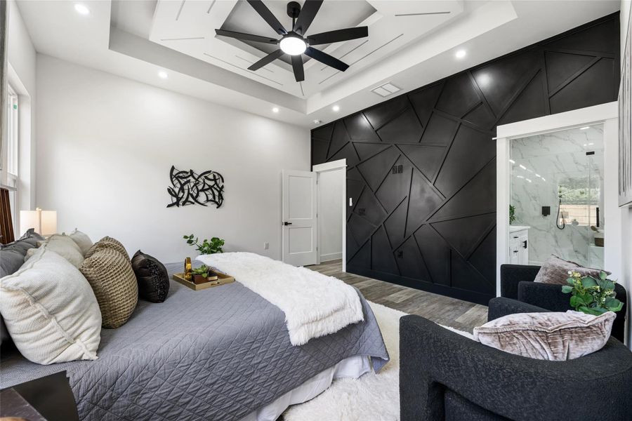 Bedroom featuring an accent wall with geometric paneling and wood-finish flooring
