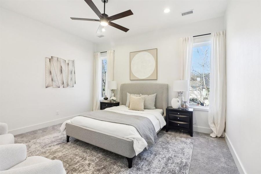 Bedroom with ceiling fan and light carpet