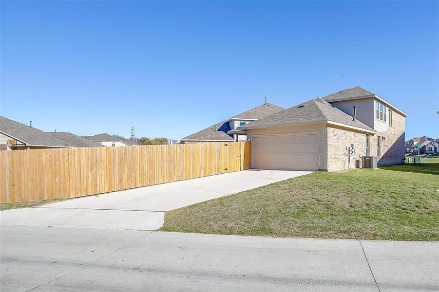 View of property exterior featuring cooling unit, a garage, and a yard