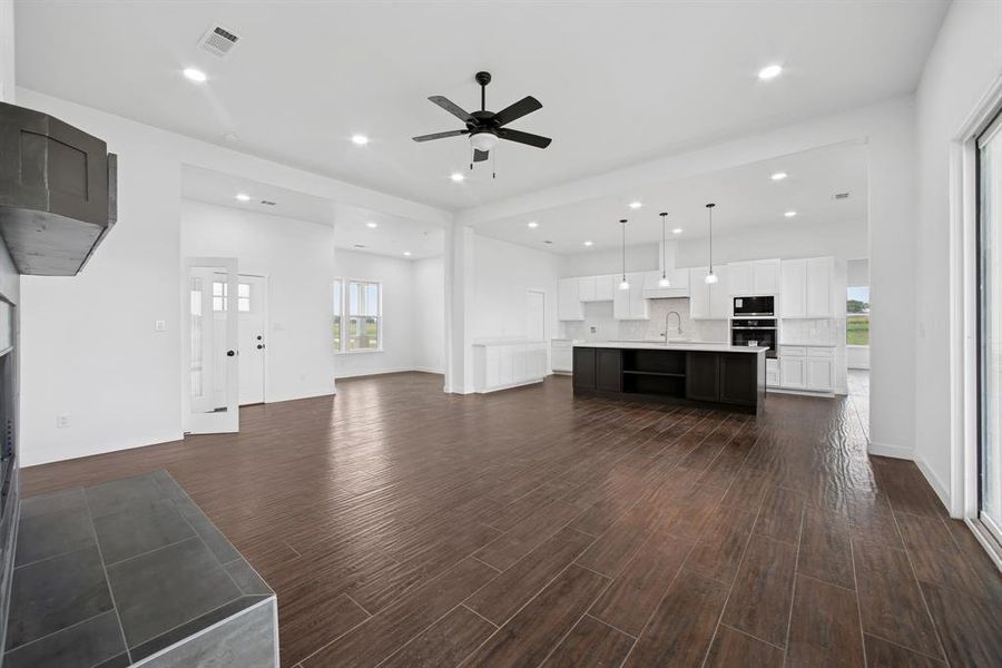 Unfurnished living room with dark wood-style floors, recessed lighting, and a ceiling fan