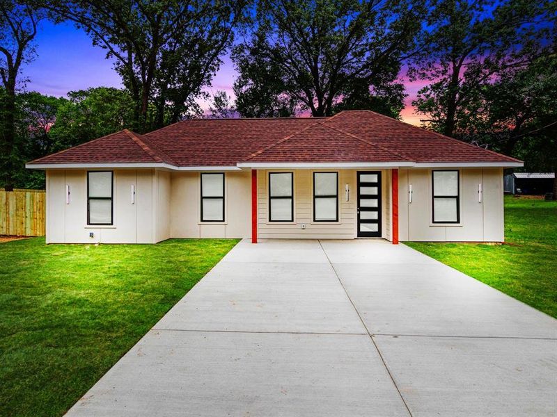 Contemporary-style home featuring a red shingle roof, cream-colored siding, and a modern black entry door with frosted glass panels Contemporary-style home featuring a red shingle roof, cream-colored siding, and a modern black entry door with frosted glass panels