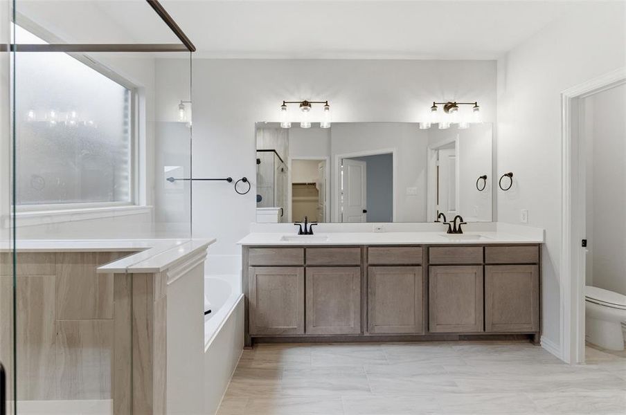 Dual vanity with light wood-finish cabinetry and white countertops