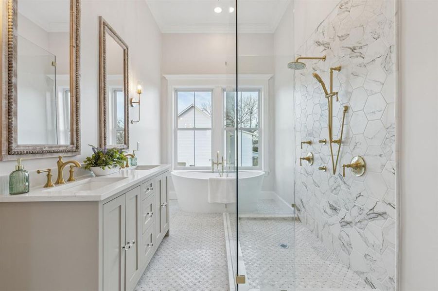 primary bathroom with separate soaking tub, shower, and dual sinks