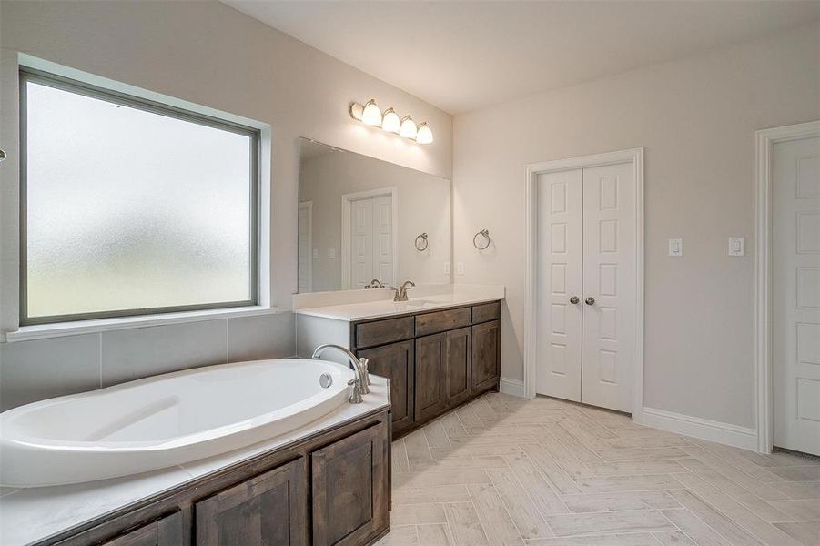 Bathroom with a tub to relax in and vanity