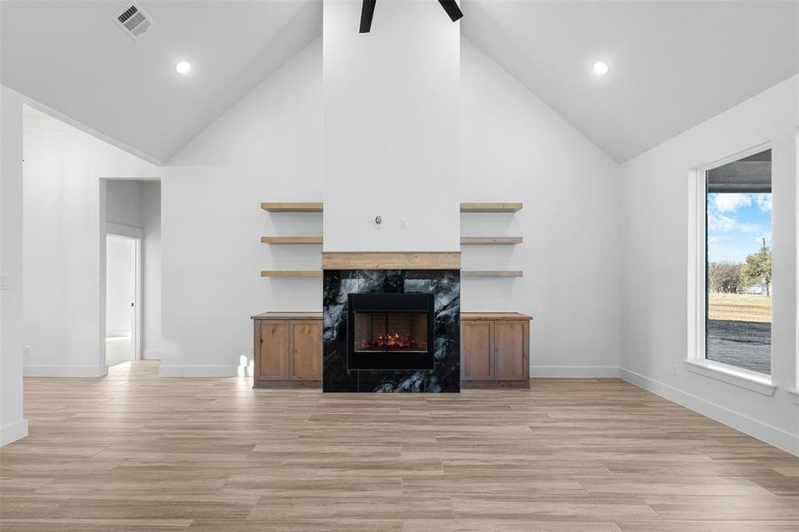 Living room featuring high vaulted ceiling and a fireplace