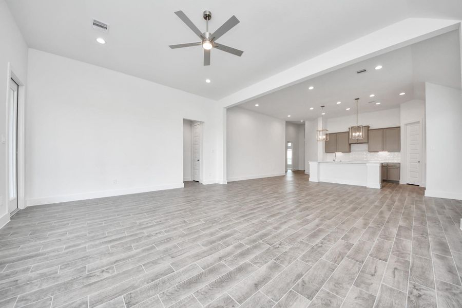 Gather the family and guests together in your lovely living room! Featuring soaring high ceilings, recessed lighting, ceiling fan, custom paint, gorgeous floors, and large windows that provide plenty of natural lighting throughout the day.