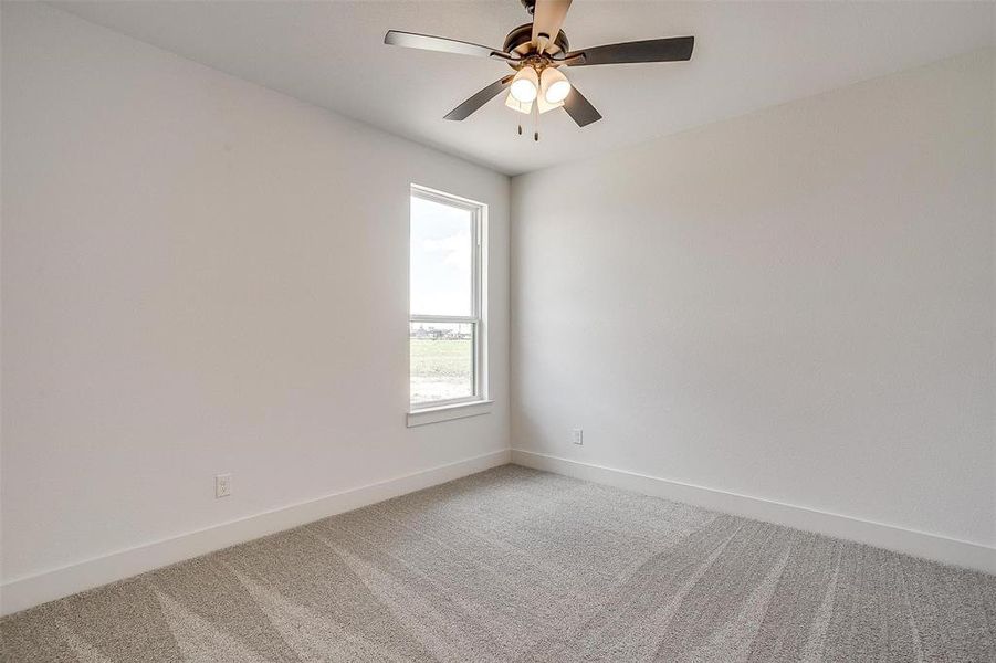 Carpeted spare room with ceiling fan