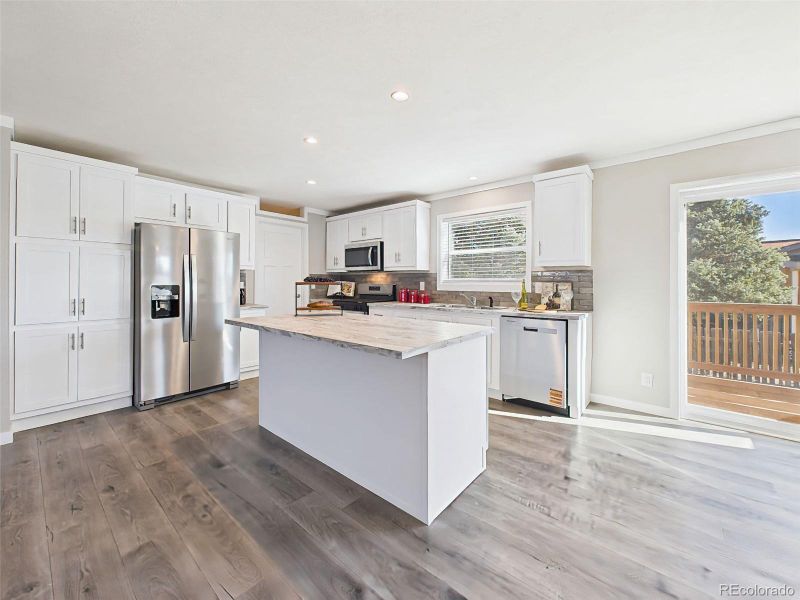 Kitchen Island & Workspace – The expansive center island offers additional prep space and seating, while the long counter run provides ample room for cooking and entertaining.