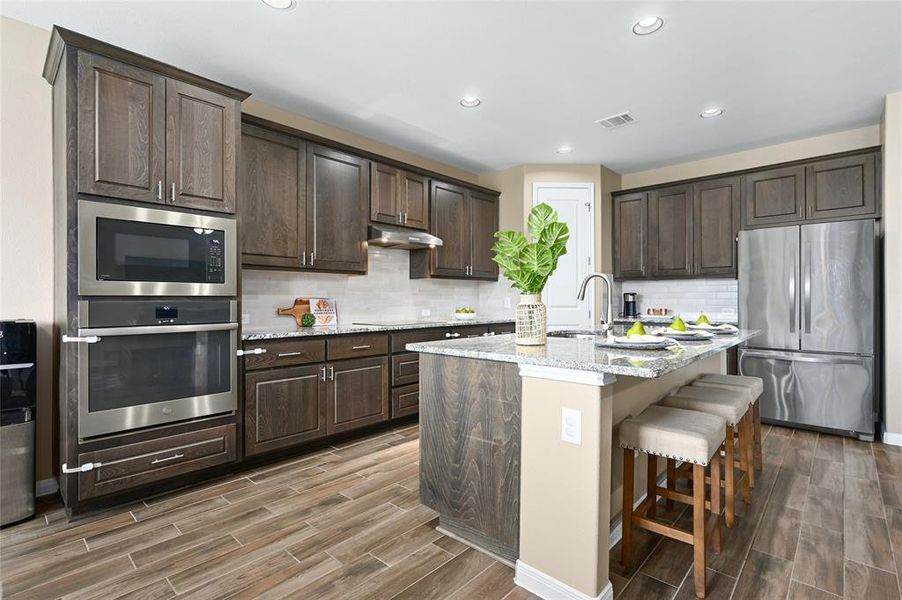 Gourmet kitchen offering built-in appliances, gorgeous granite countertops and recessed lighting.